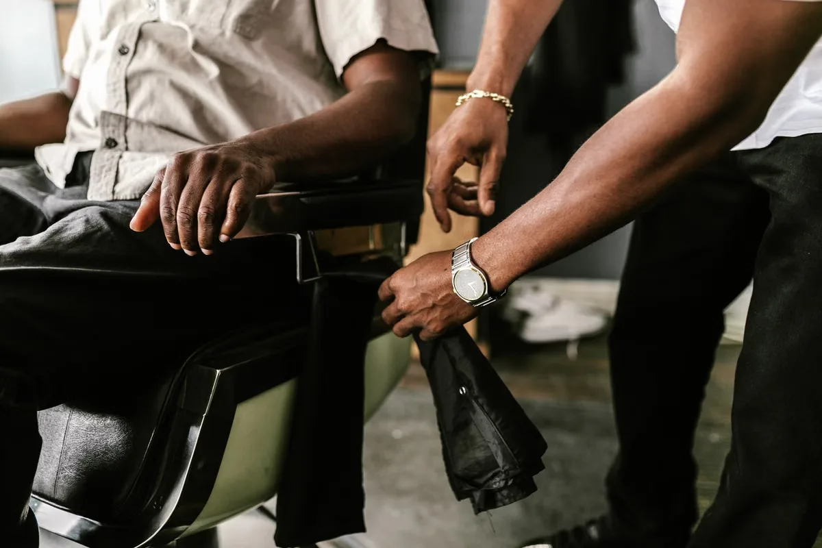 Barber putting the cape on a client